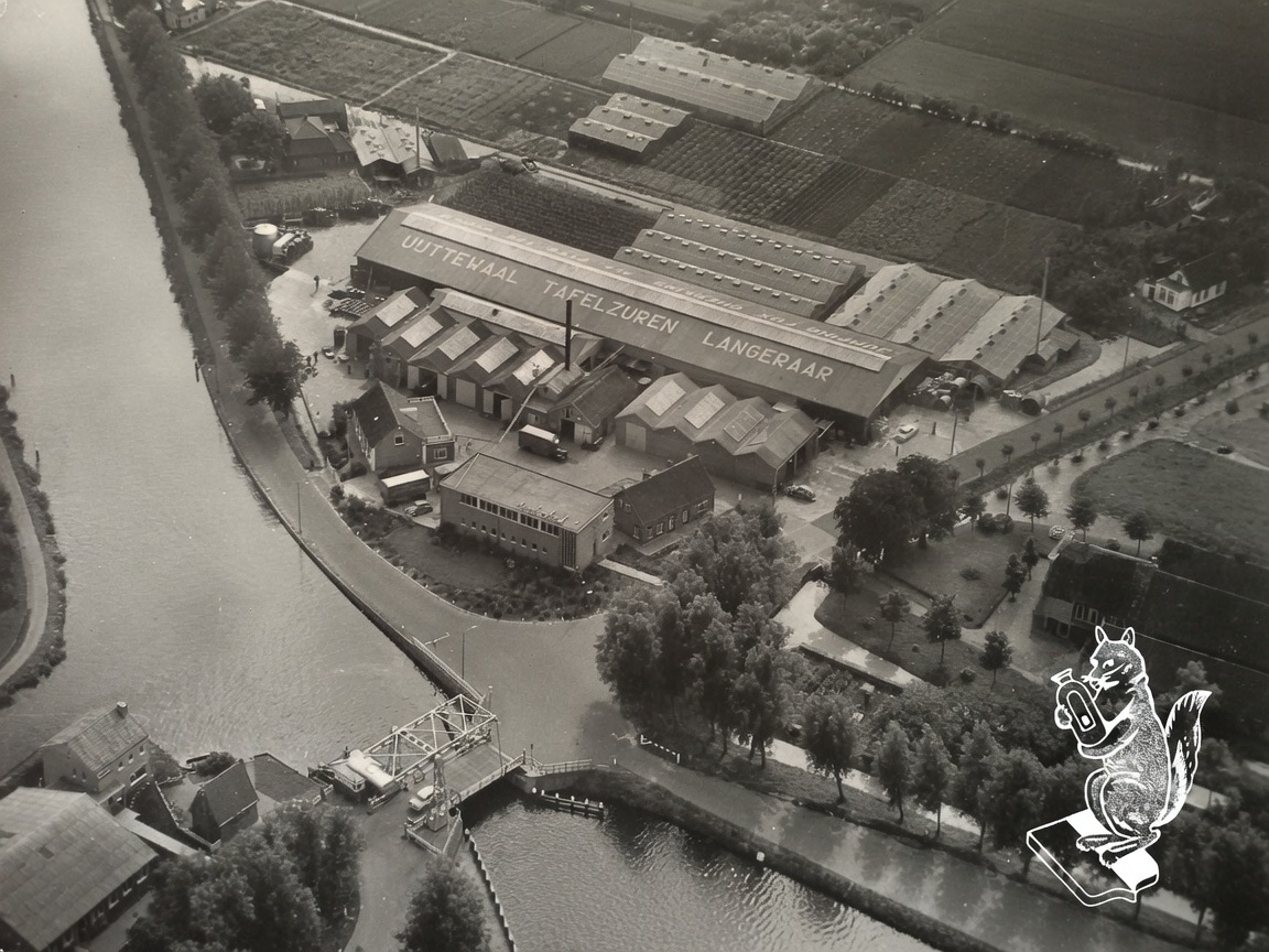 Luchtfoto van conservenfabriek L.P. Uijttewaal aan de Kattenbrug, Westkanaalweg 1. Aan de andere kant van het dak staat de tekst Jumping Fox Gherkins All Over The World. De gedach…