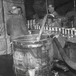 Appelmoes maken onder toeziend oog van bedrijfsleider Wim Uijttewaal, 1958.